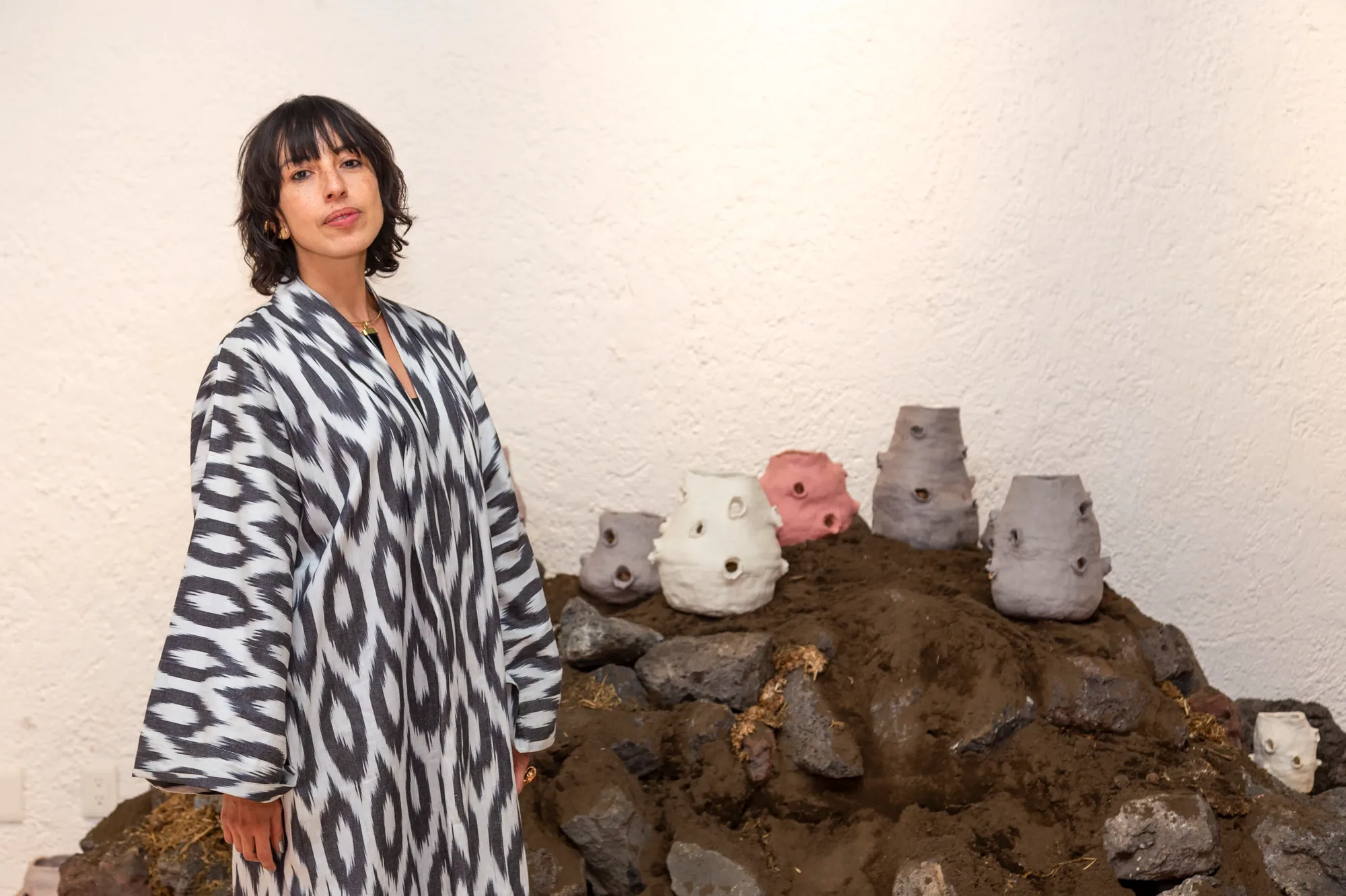 Artist portrait beside a ceramic installation, Aki Aora 2025