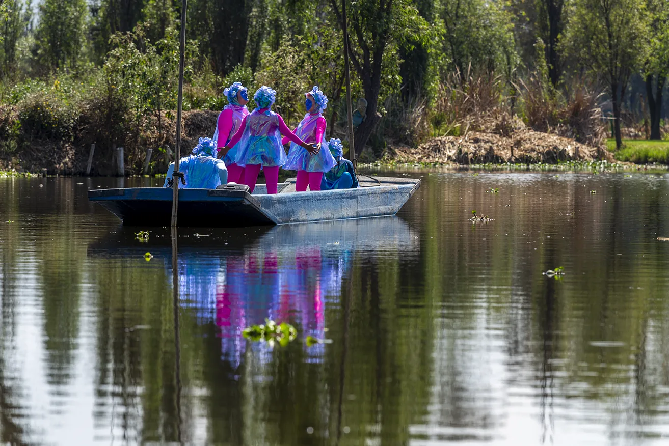 Performers in pink and blue costumes on a trajinera, Xochimilco