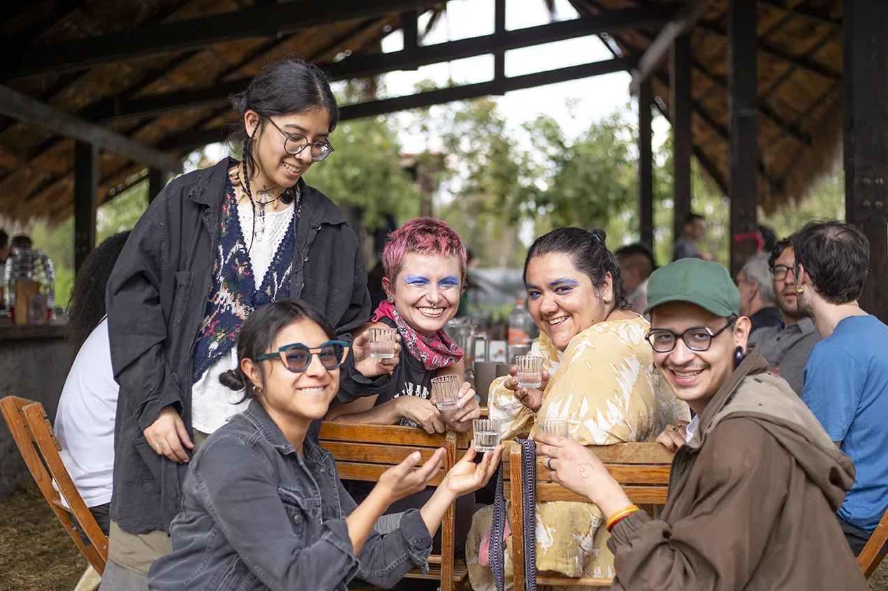 Group toasting under a palapa, Aki Aora 2025