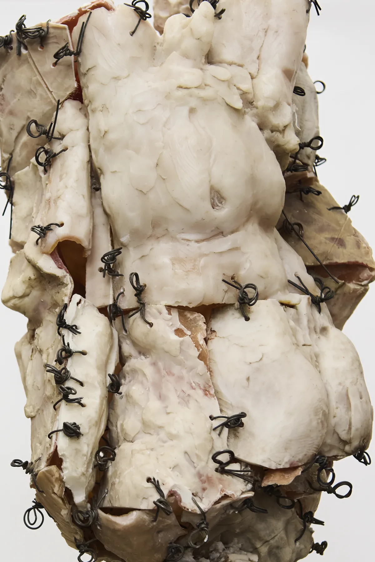 Close detail of wire-stitched sculpture torso