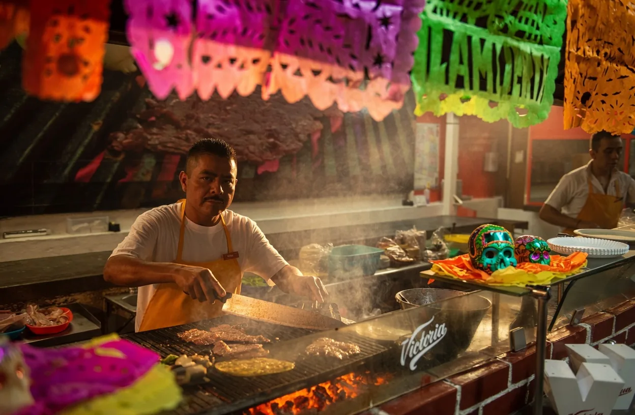 Taquero cooking under papel picado